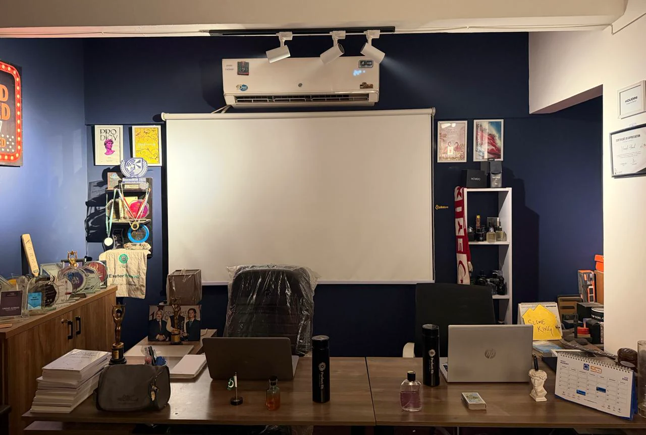 The Houdini Digital office, navy walls with campaign posters, awards and a fragrance shelf
